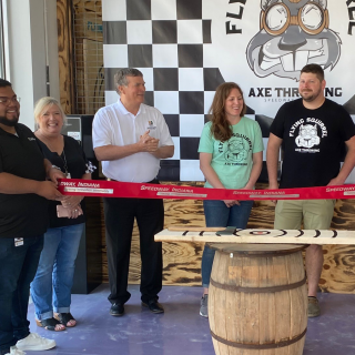 Ribbon being cut at grand opening of Flying Squirrel Axe Throwing