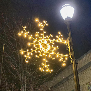 Lighted snowflake hanging on light pole as holiday decor on Main Street