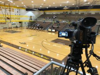 Camera on tripod filming in Speedway Schools gym